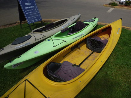 Single and tandem kayaks for rent – hard surface parking lot – sidewalk – soft surface by sidewalk